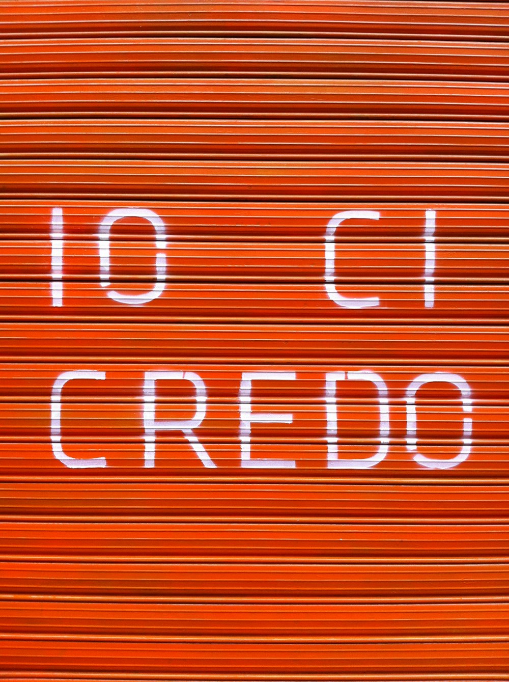 a close up of a closed red door with the words 10 ci credo
