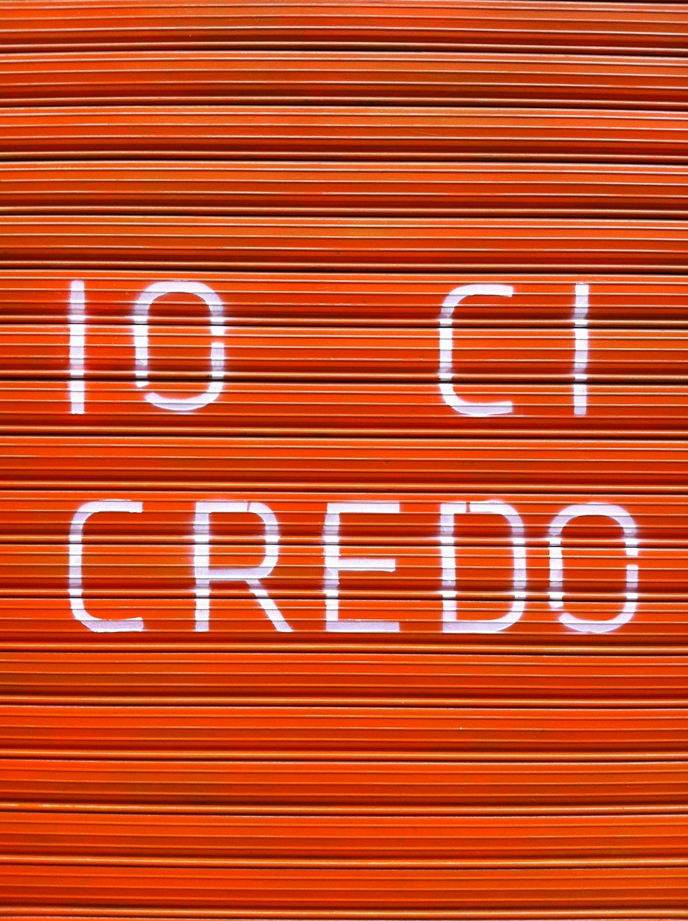 Un primer plano de una puerta roja cerrada con las palabras 10 ci credo