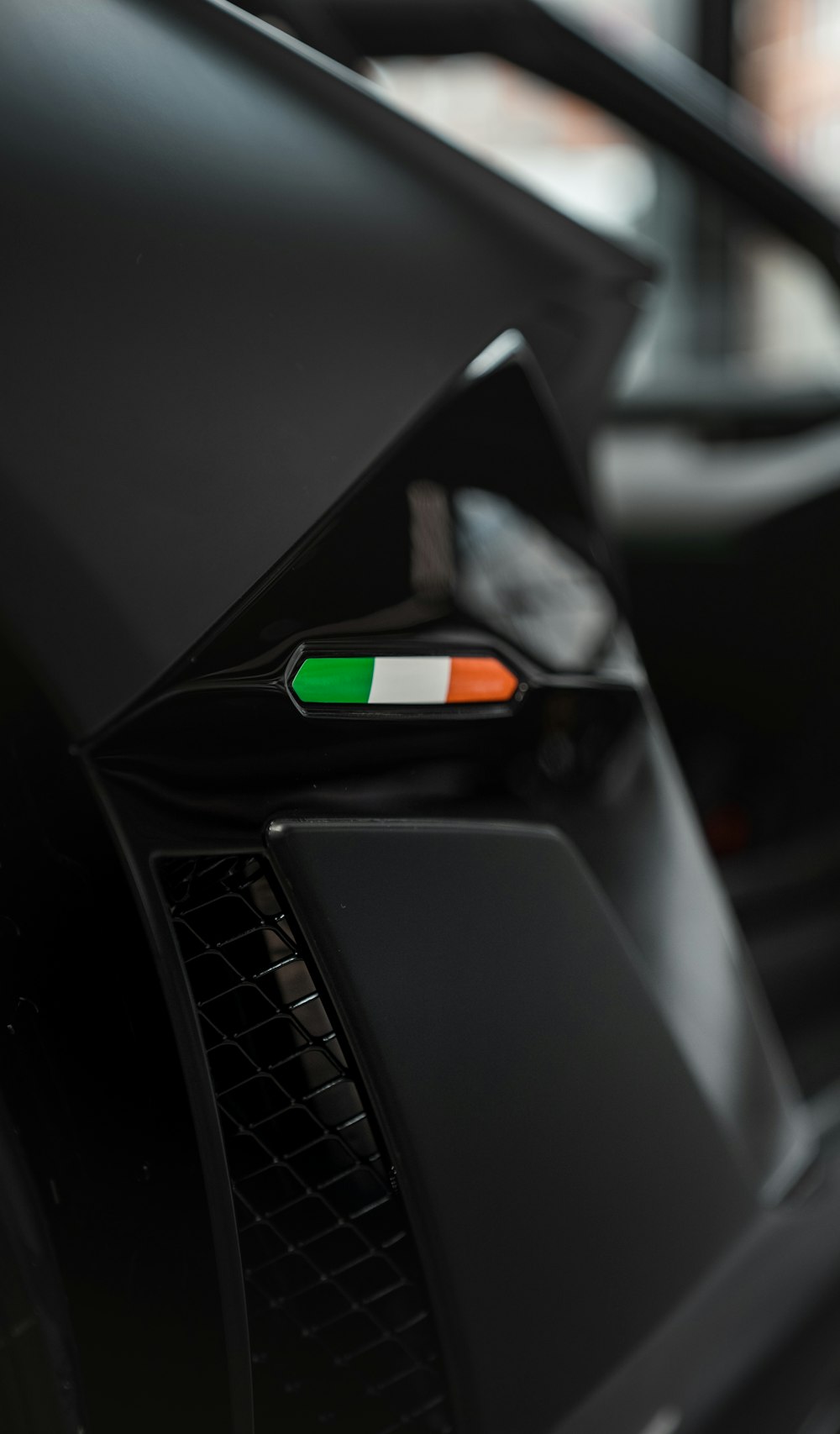 a close up of a black car with a green light