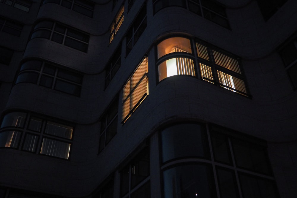 a tall building with windows lit up at night