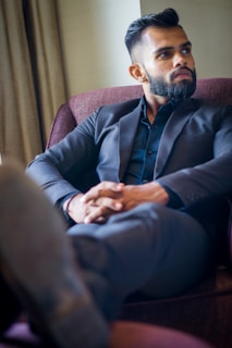 a man in a suit sitting in a chair