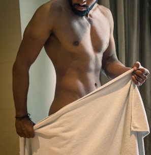 a shirtless man holding a white towel