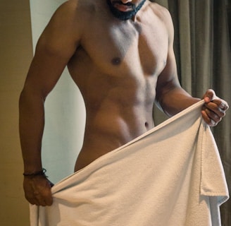 a shirtless man holding a white towel