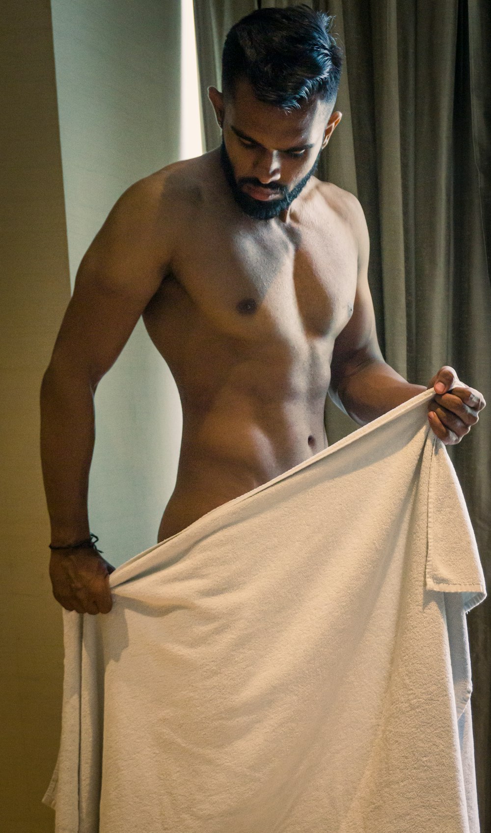 a shirtless man holding a white towel