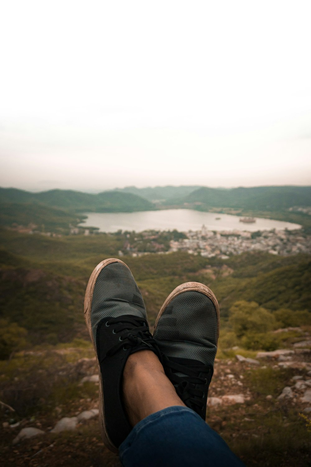 a person's feet with a view of a lake and mountains