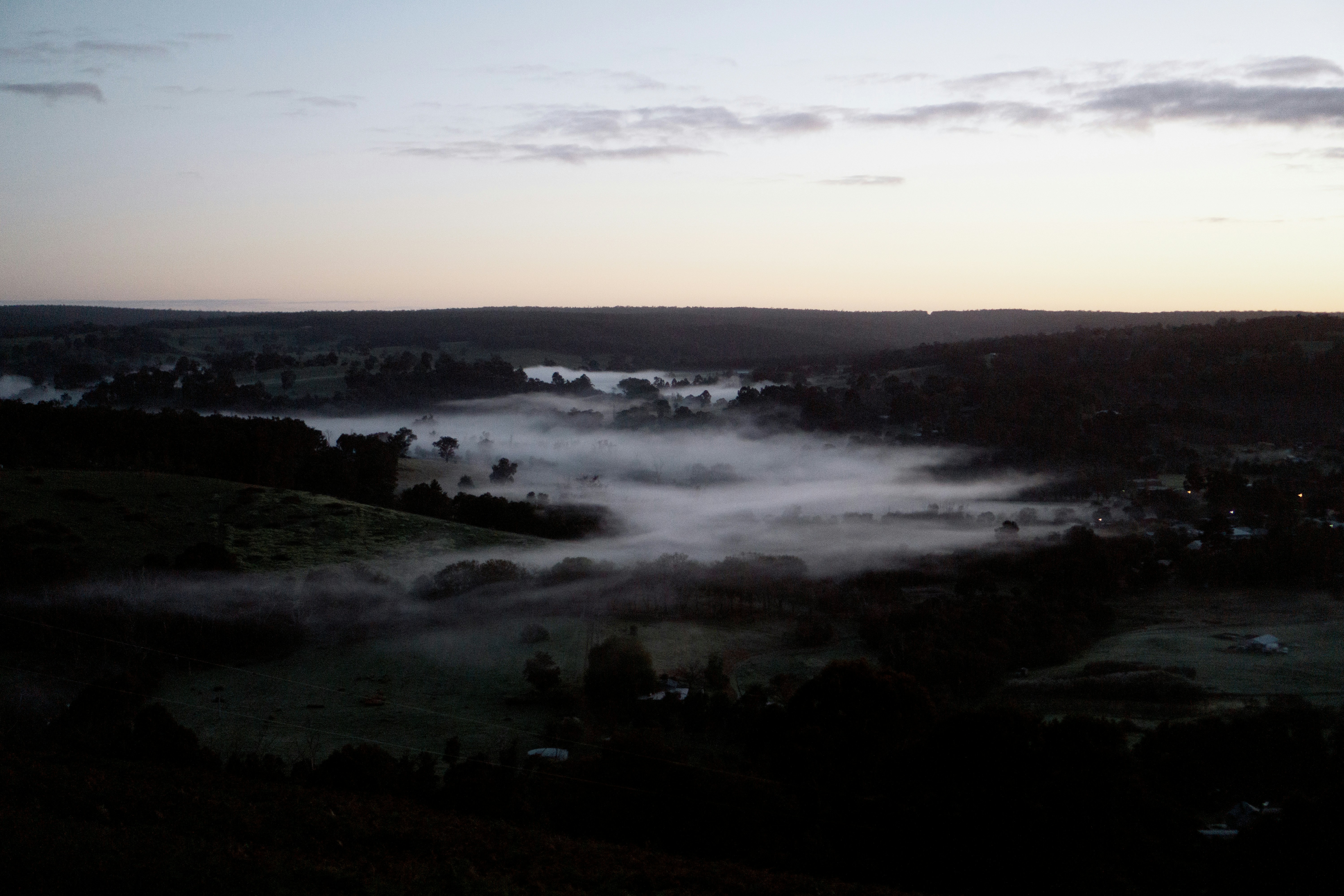 a view of a foggy valley at sunset