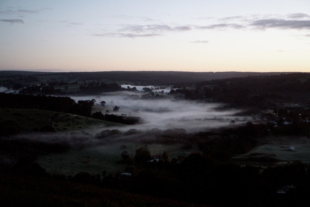 a view of a foggy valley at sunset