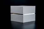 Minimalist photo of a sleek custom box with clean lines on a pale gray background.