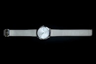 Minimalist watch face with clean lines and a silver mesh band catching the light.