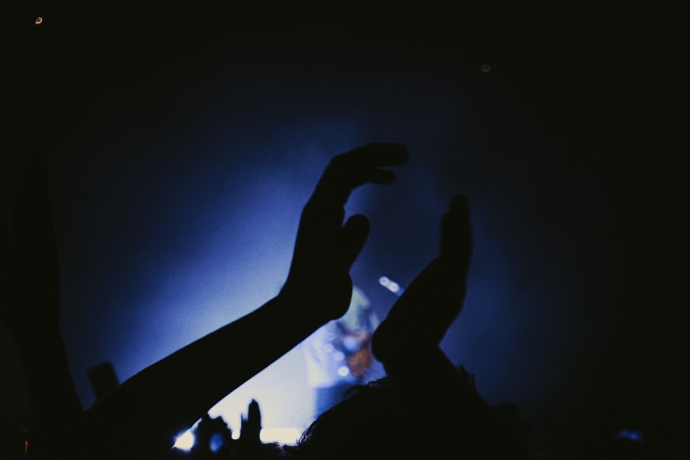 a crowd of people raising their hands in the air