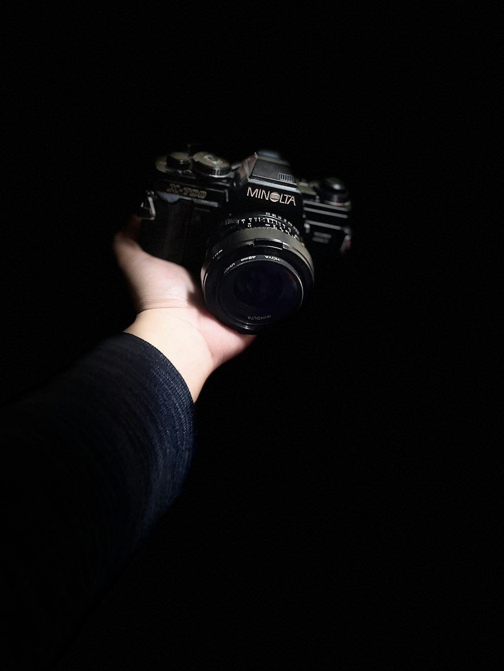 a person holding a camera in the dark