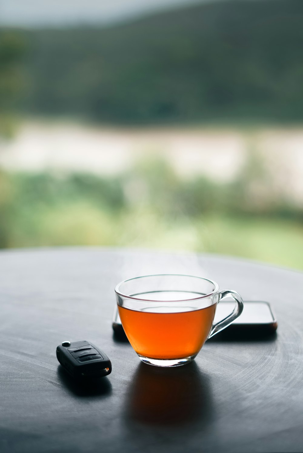 a cup of tea and a cell phone on a table