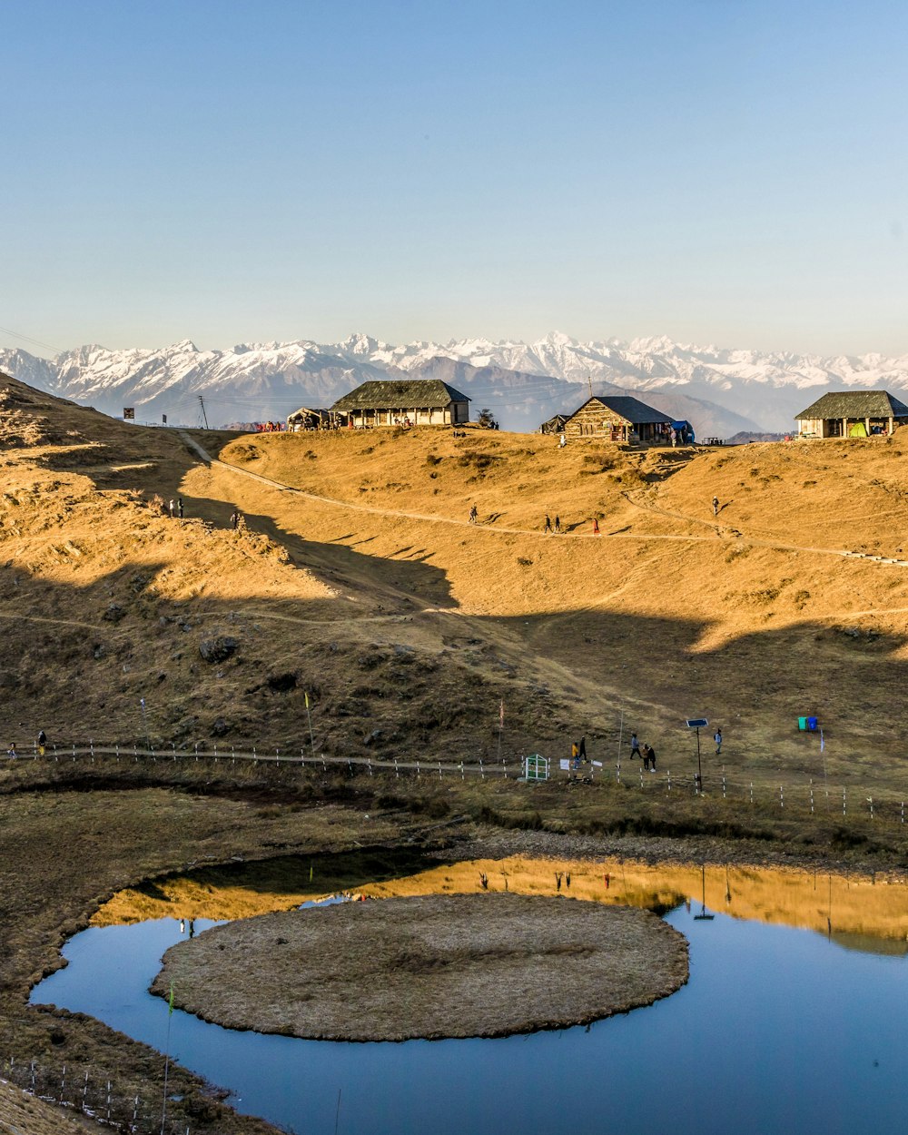 a group of houses sitting on top of a hill next to a lake