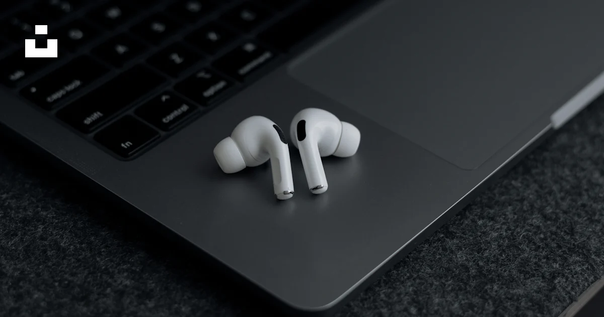 Computer Ear Plug A pair of ear buds sitting on top of a laptop photo – Free Home office ...
