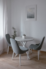 A small dining nook with a round table, modern chairs, and a statement pendant light.