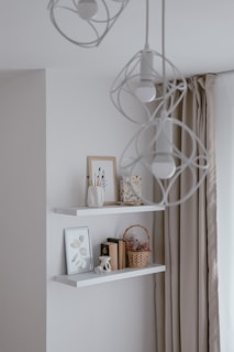 a white shelf with books and pictures on it