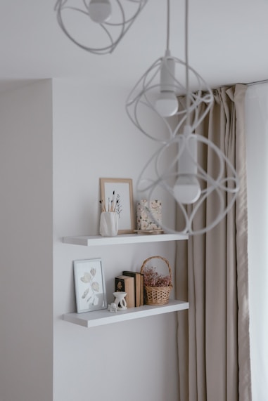 a white shelf with books and pictures on it