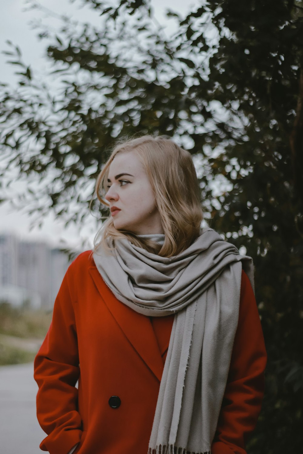 a woman wearing a red coat and a gray scarf