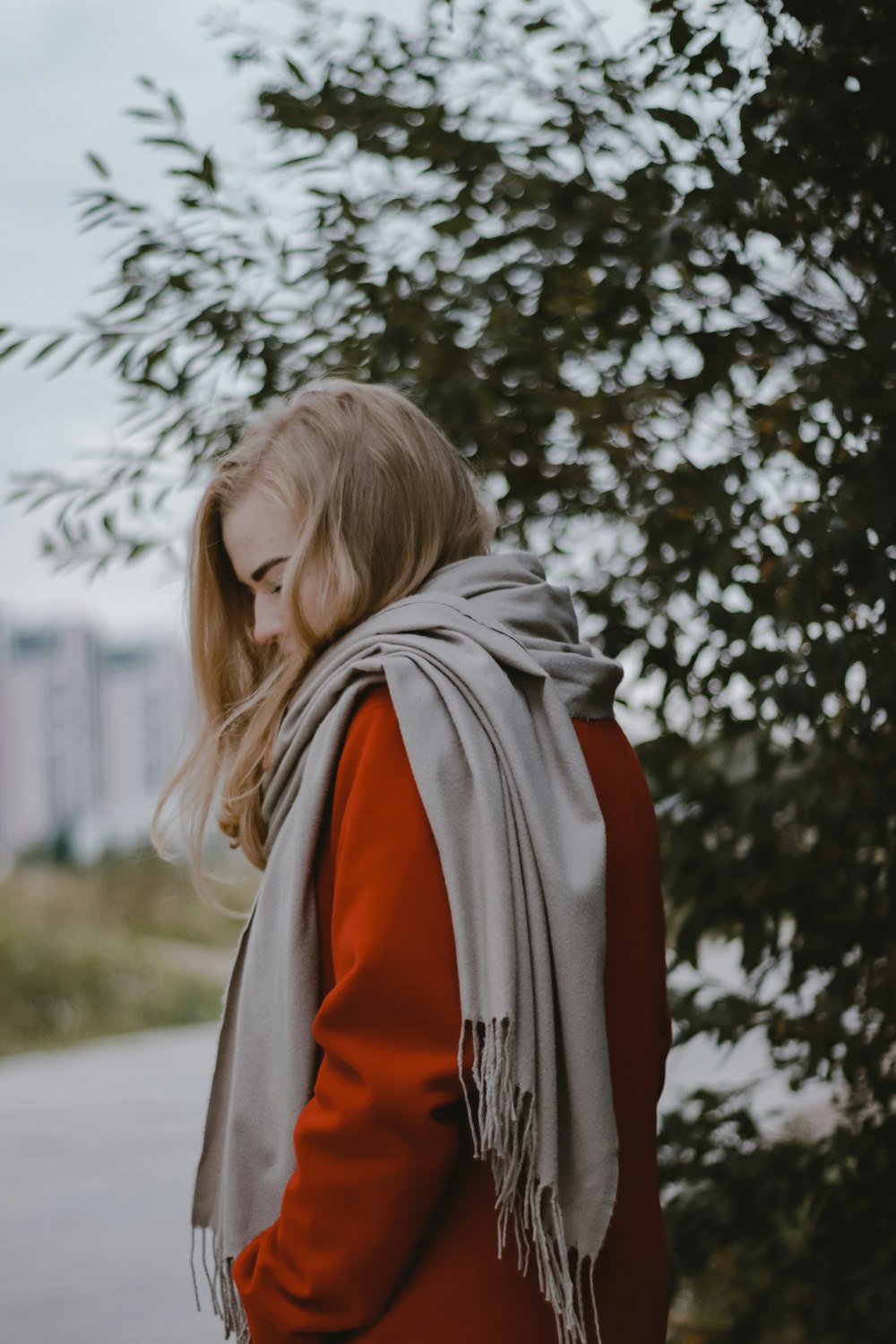 a woman wearing a red jacket and a gray scarf