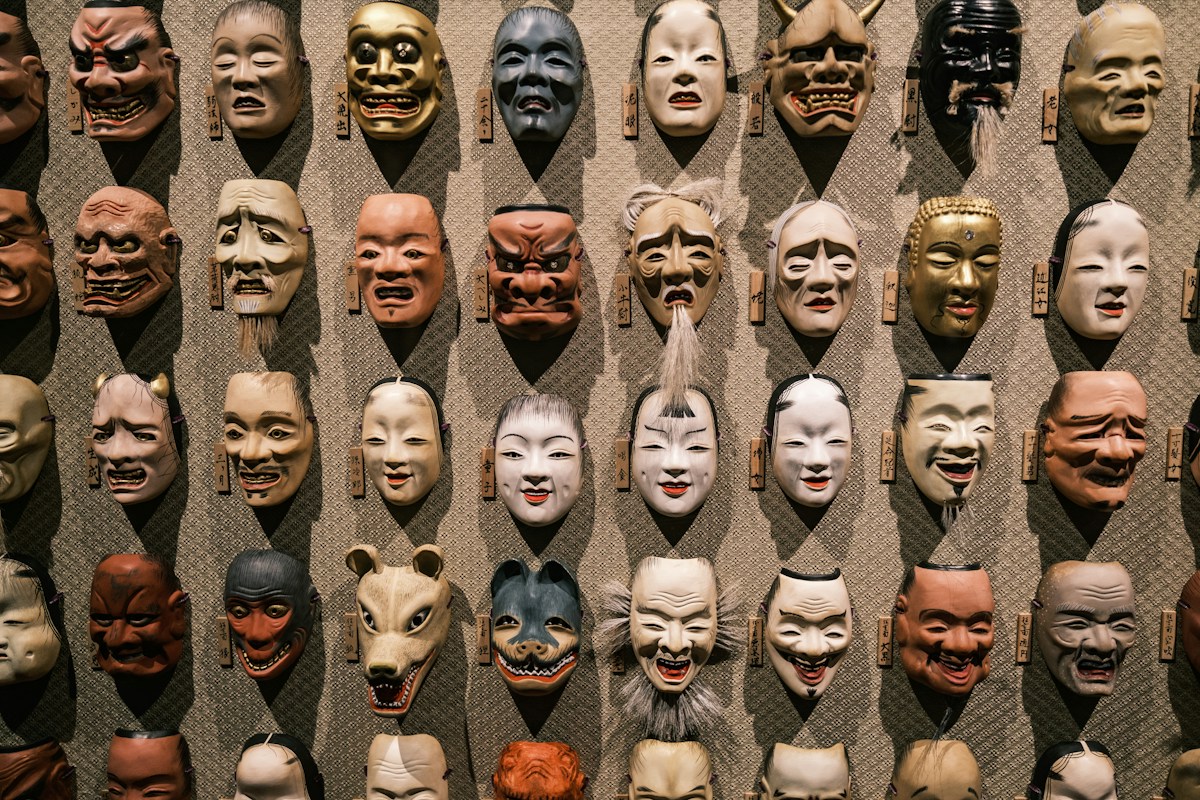 Uma parede com muitas máscaras japonesas coloridas.