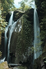 a large waterfall in the middle of a forest