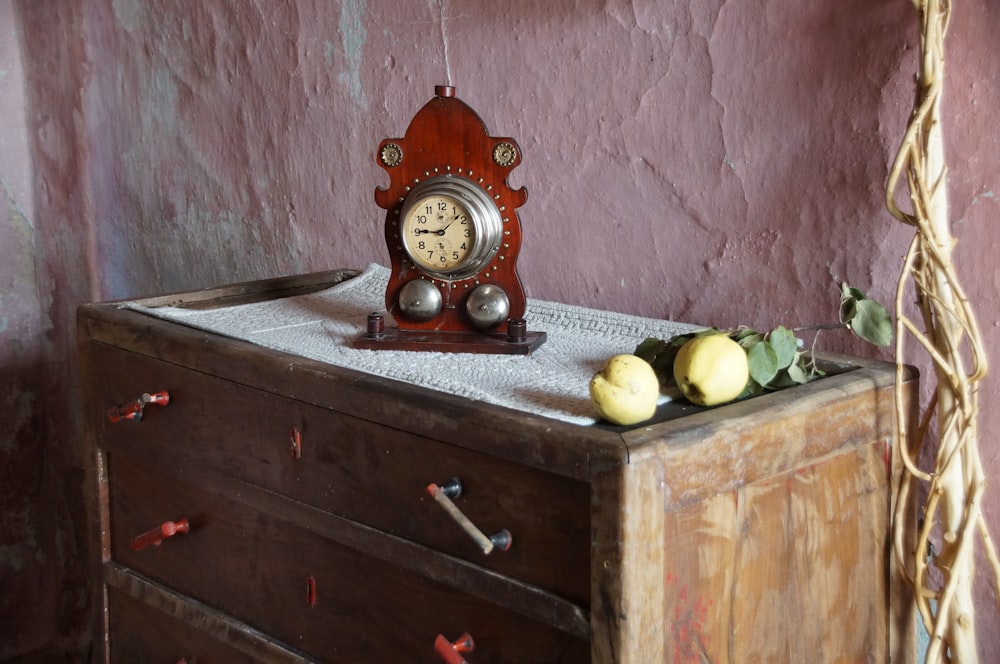 a clock sitting on top of a wooden dresser