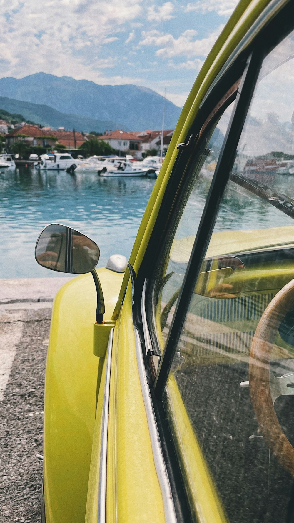 a yellow car parked next to a body of water