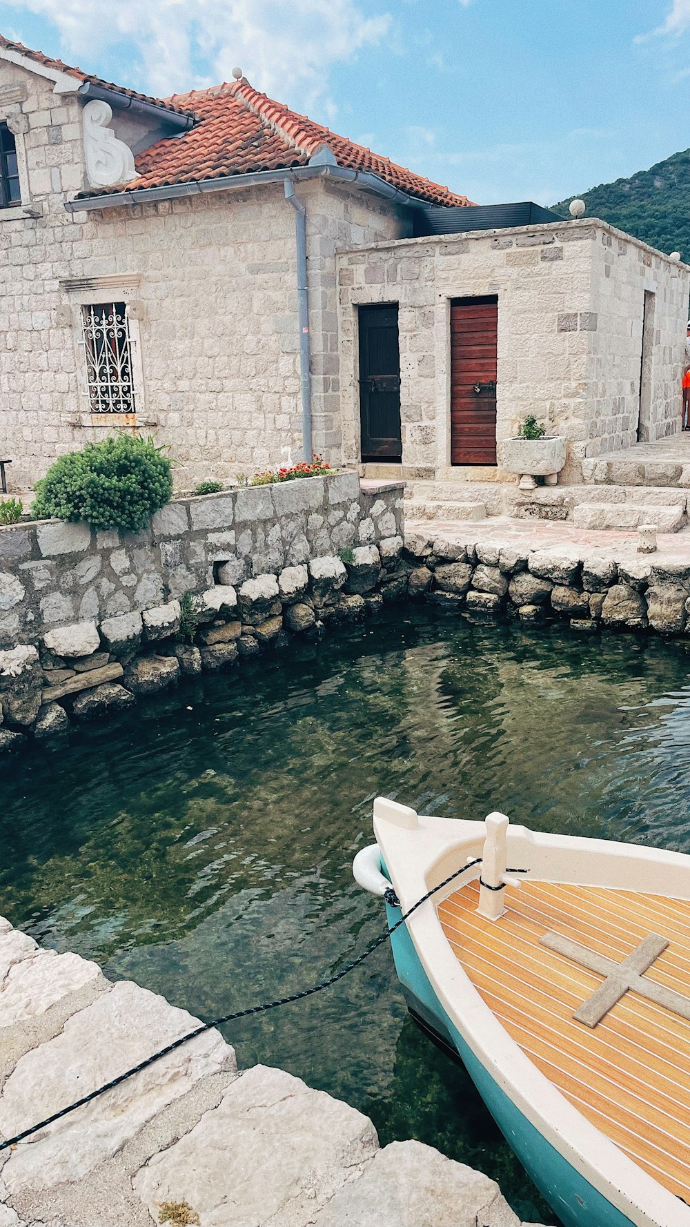 a small boat sitting in the water next to a stone building