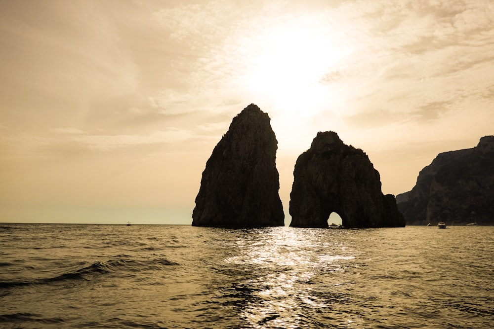 un paio di grandi rocce sedute nel mezzo di uno specchio d'acqua