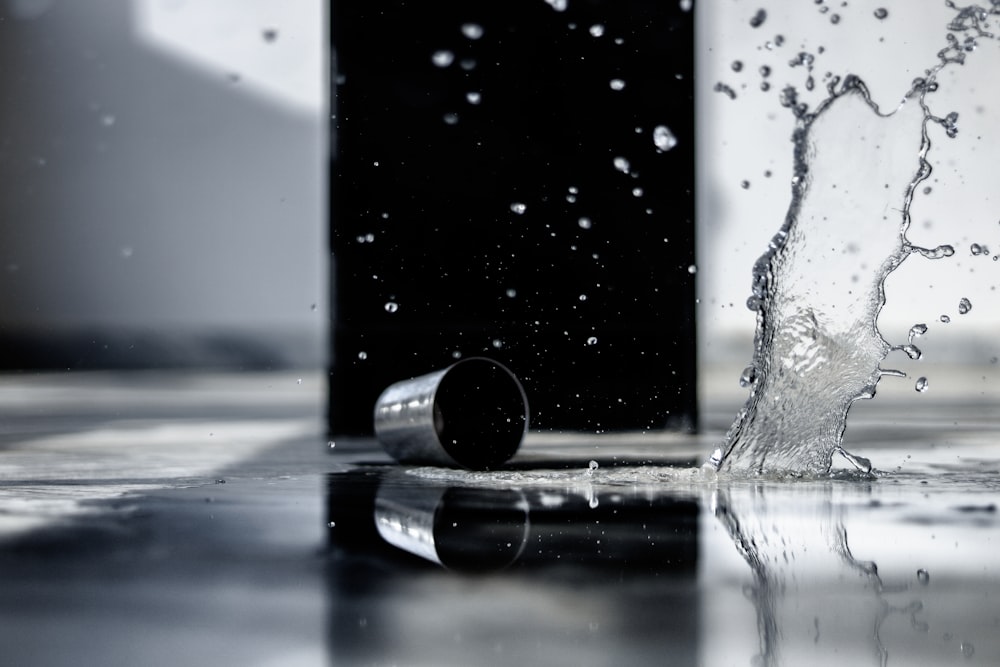 a black and white photo of water splashing on the floor