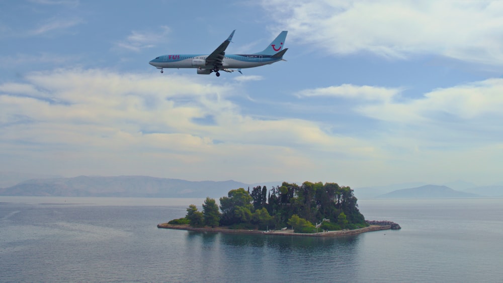 an airplane flying over a small island in the middle of the ocean