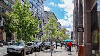 a group of people walking down a street next to tall buildings