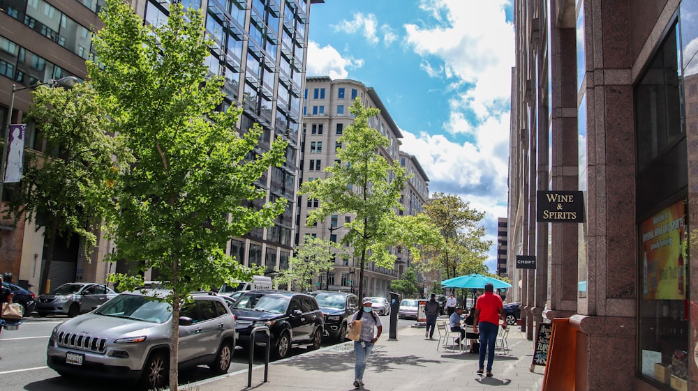 a group of people walking down a street next to tall buildings