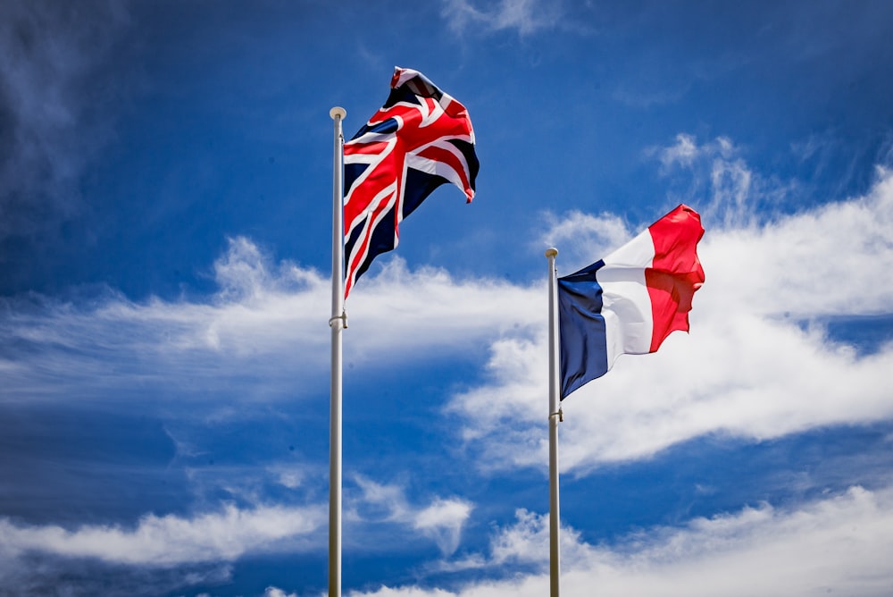 two flags flying in the wind on a cloudy day