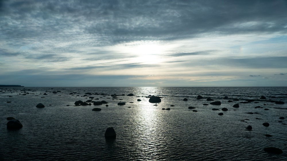 the sun shines through the clouds over the ocean