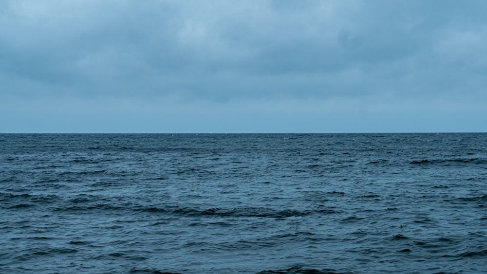 a large body of water under a cloudy sky