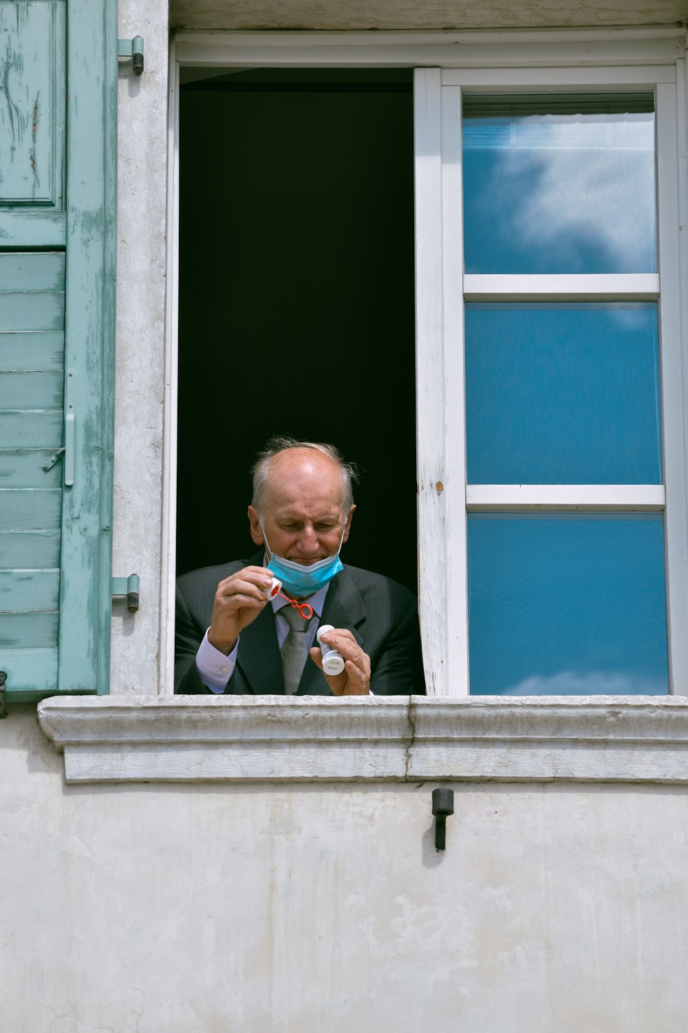 a man in a suit and tie looking out a window