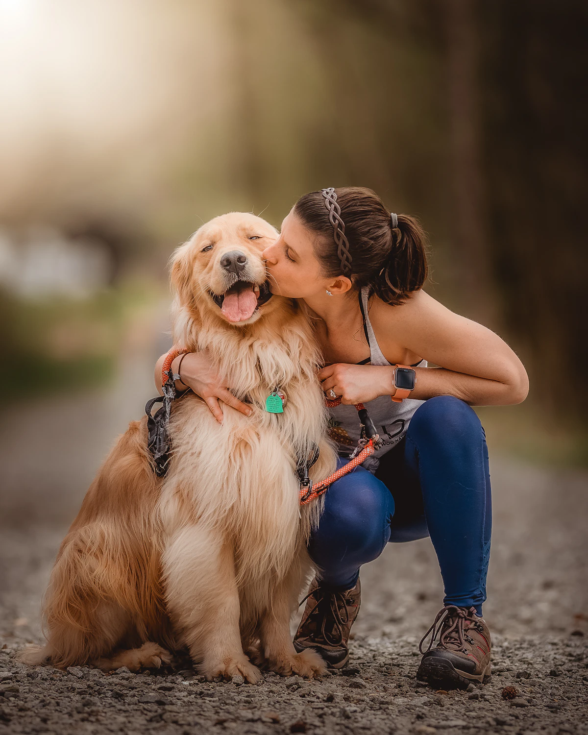A woman kissing her dog on the cheek