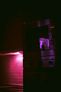 A sleek black microwave with digital touch controls glowing softly on a minimalist kitchen countertop.