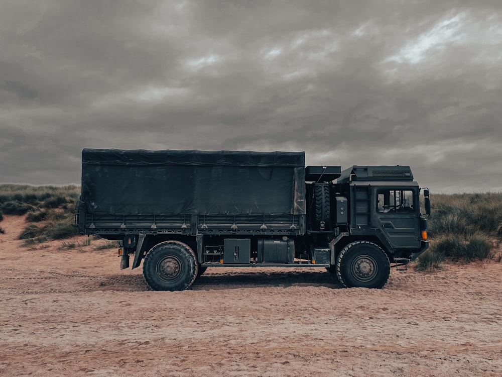 a black truck parked in the middle of a desert