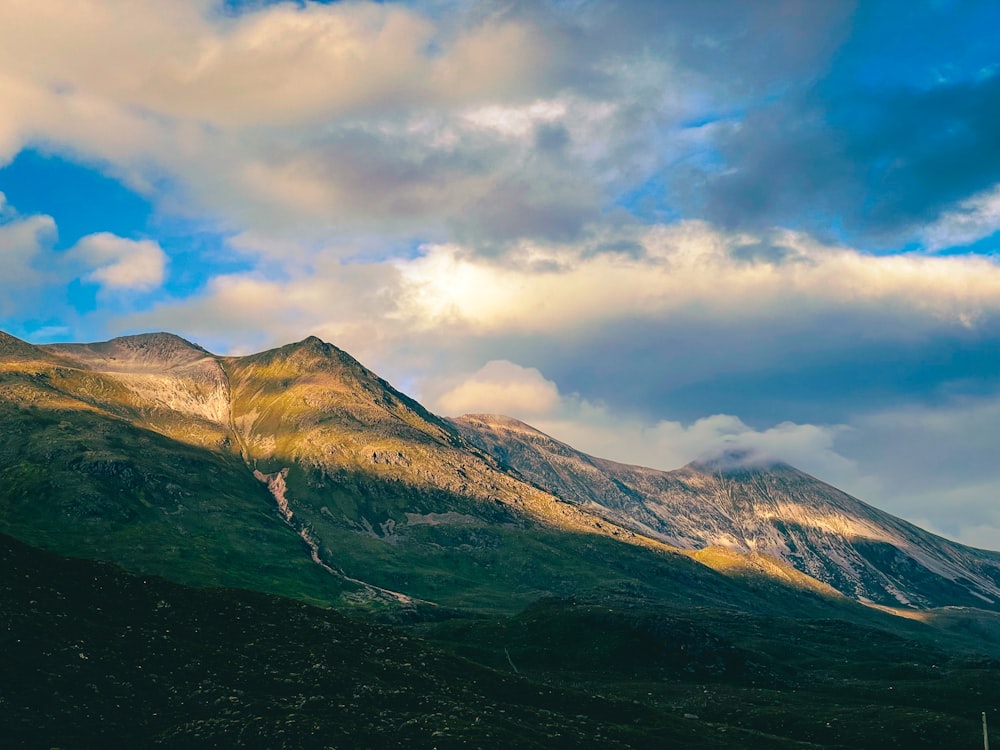 a view of a mountain with clouds in the sky