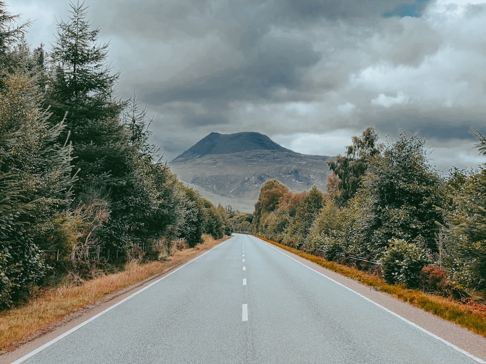 an empty road with a mountain in the background