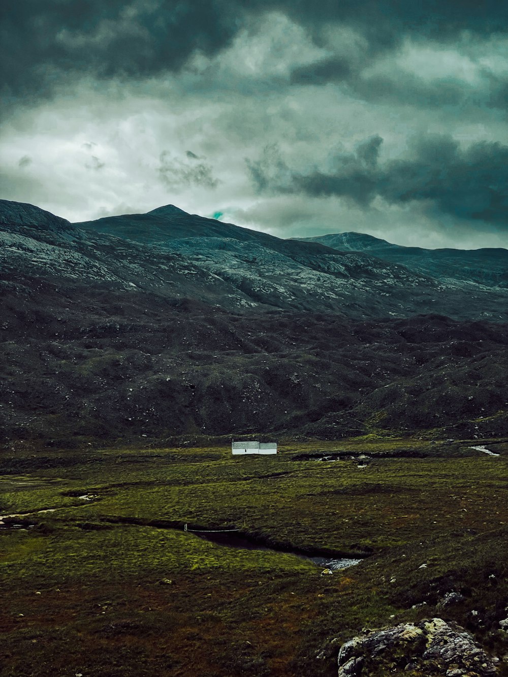 a field with a house in the middle of it