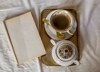 A coffee cup was placed next to a book on white sheets