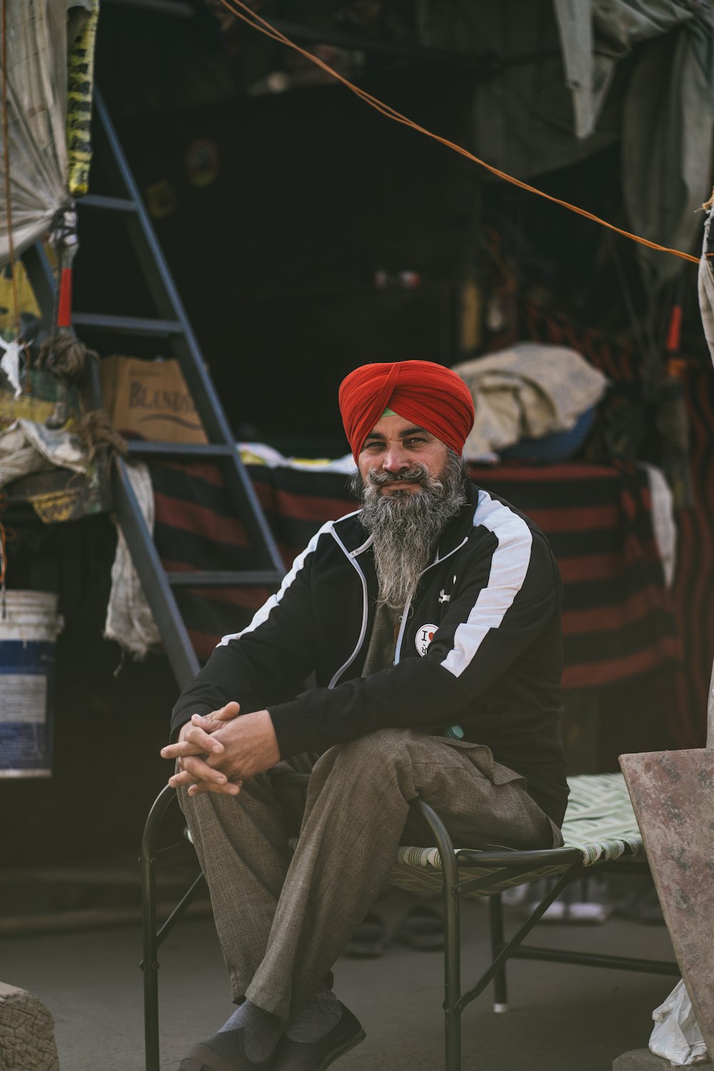 a man with a red turban sitting in a chair