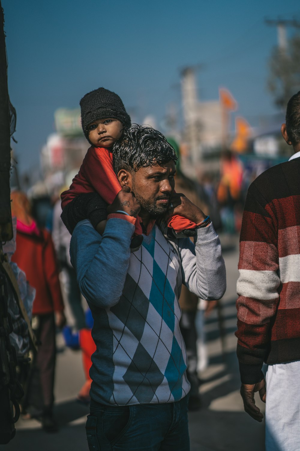 a man talking on a cell phone while holding a child