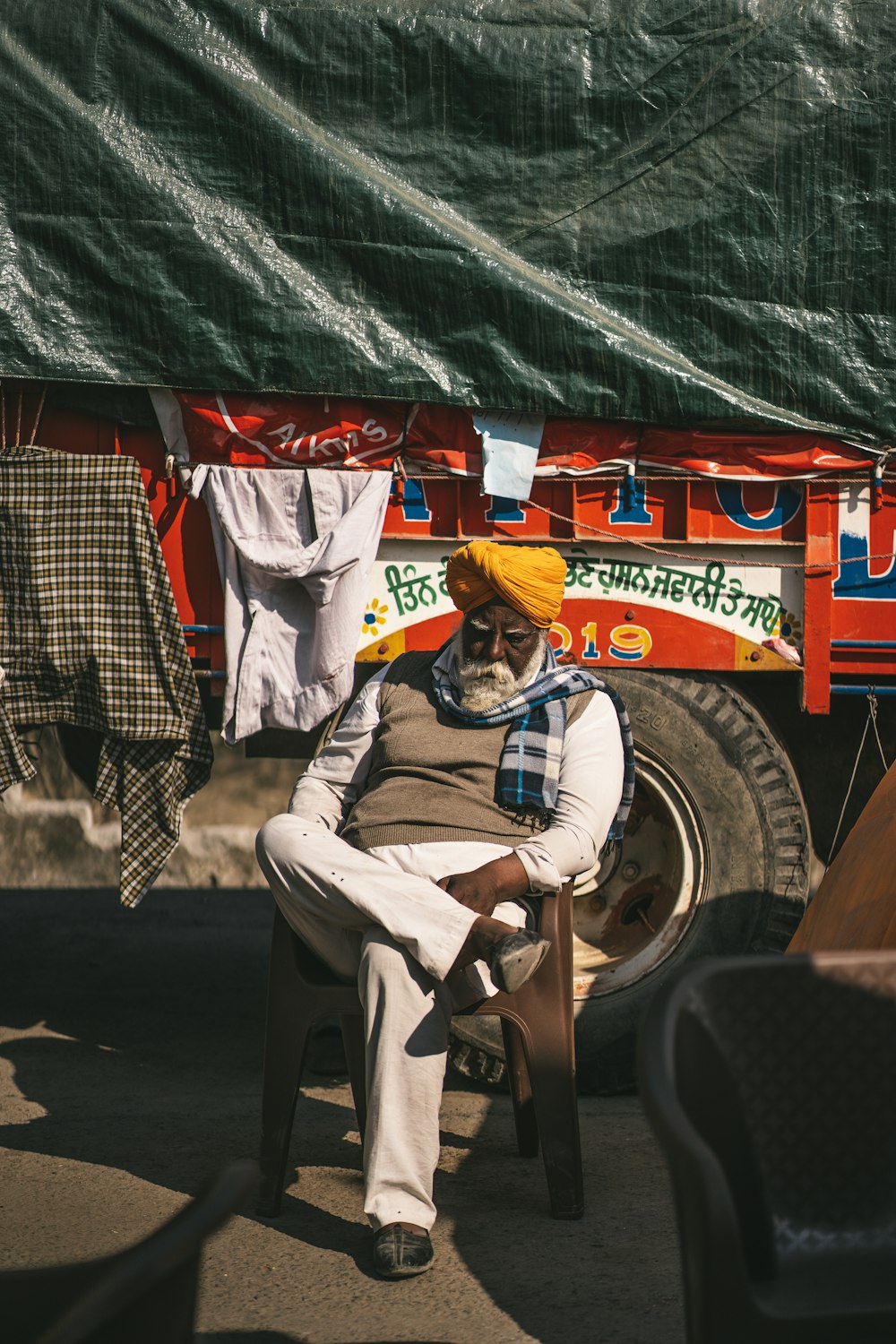 a man sitting on a chair in front of a truck