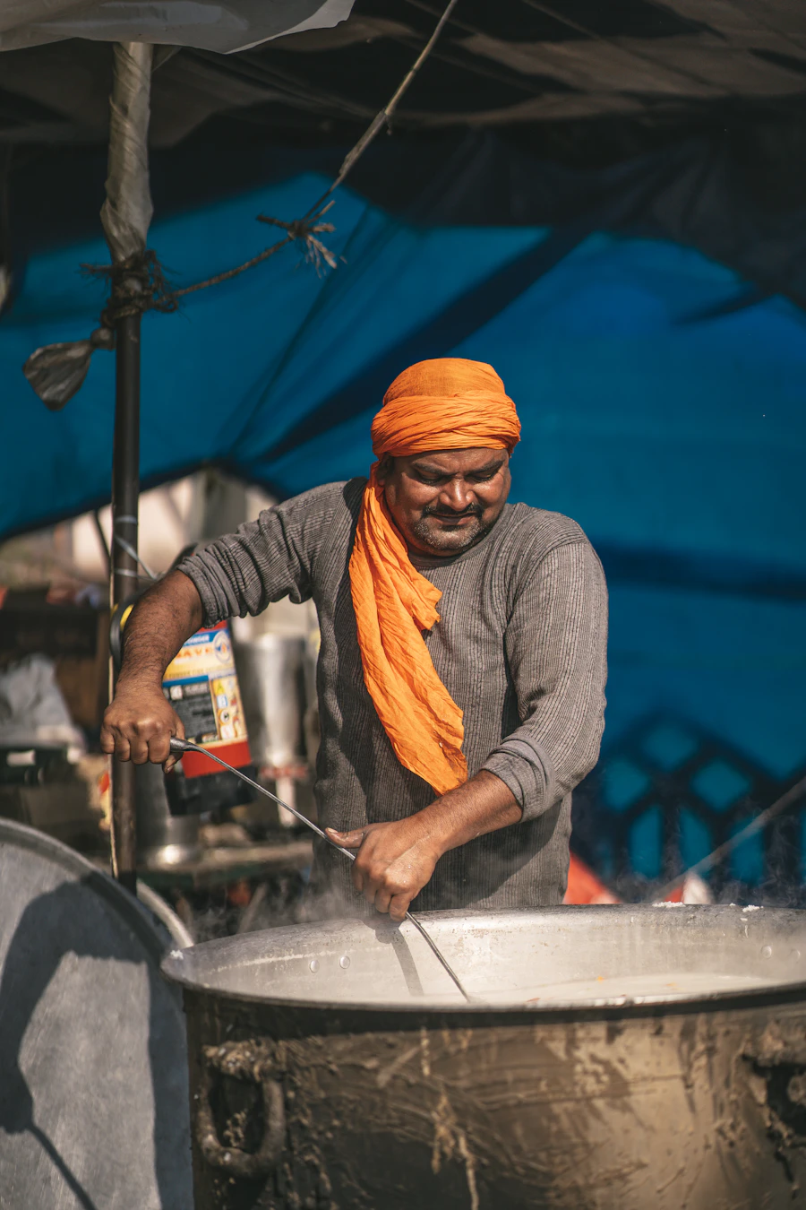 Chef tending a biryani deg over charcoal