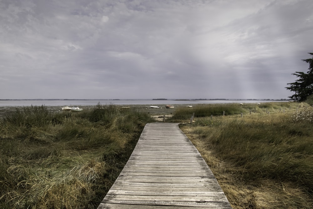 a wooden walkway leading to a beach on a cloudy day