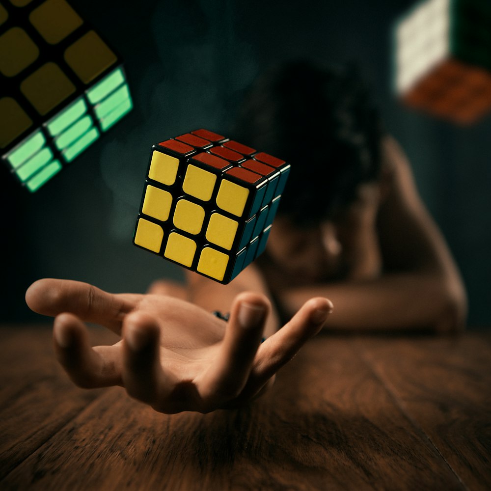 a person holding a rubik cube in their hand